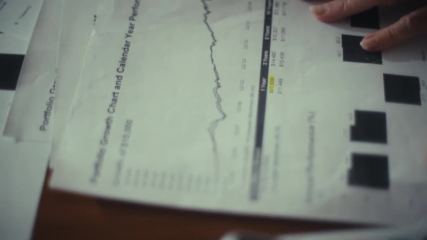 Coworkers highlight financial information and make calculations