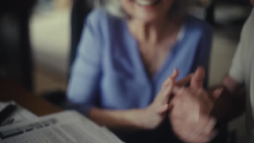 After reviewing documents with a calculator a senior couple shares a happy and affectionate moment seemingly satisfied with their financial planning