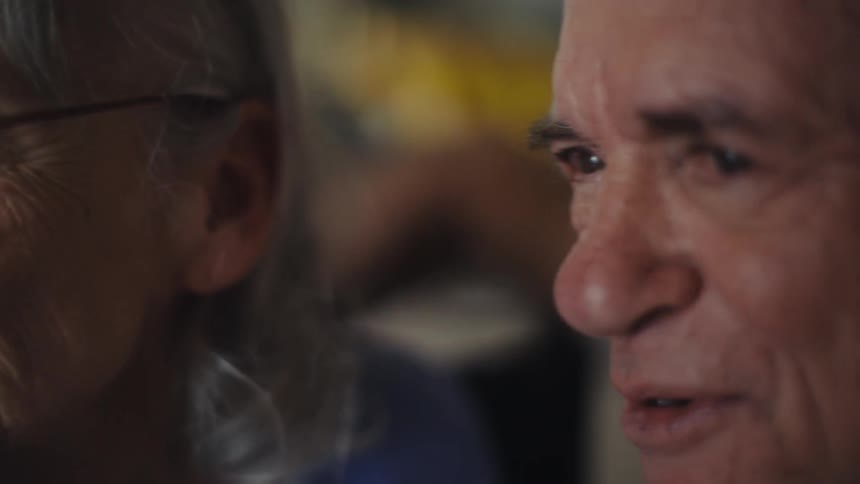 An elderly couple talks and smiles the woman is wearing glasses