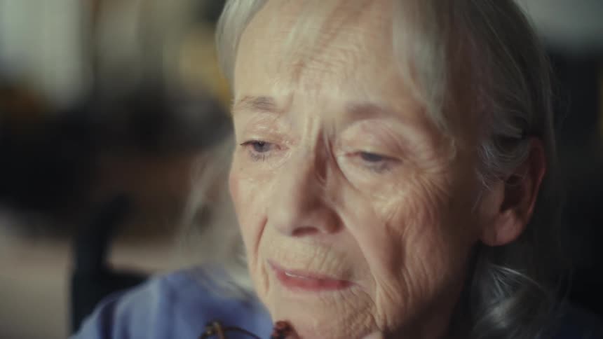 An elderly couple sit at a table reviewing documents while talking with each other