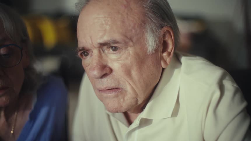 Elderly couple focuses on calculations and notes at the table