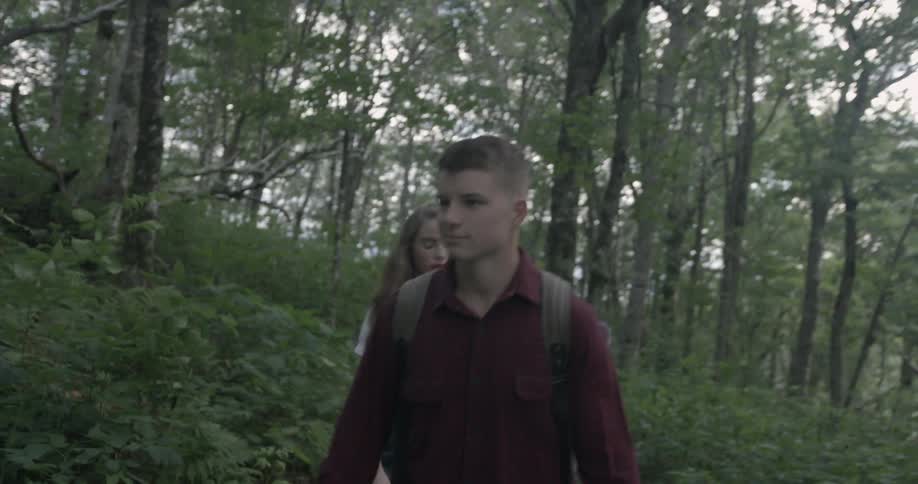 A couple down a trail in the forest