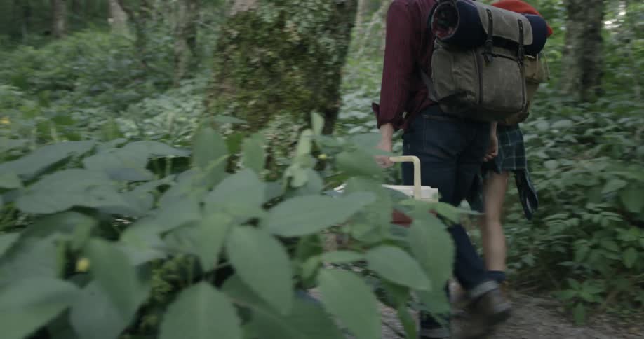 A man and woman walk through a hiking trail