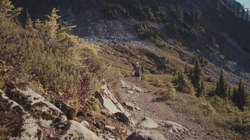 The woman is running by the mountains