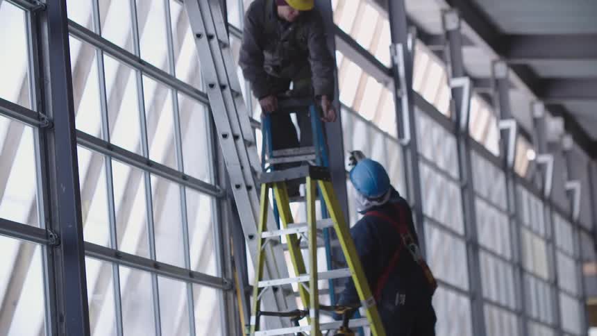 Workers performing their trade on ladders
