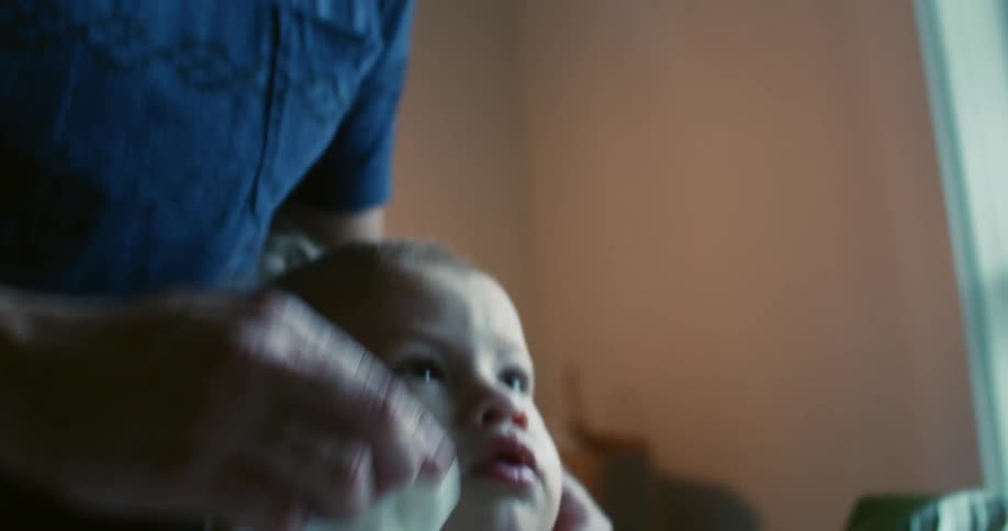 Man wipes a baby's face and mouth