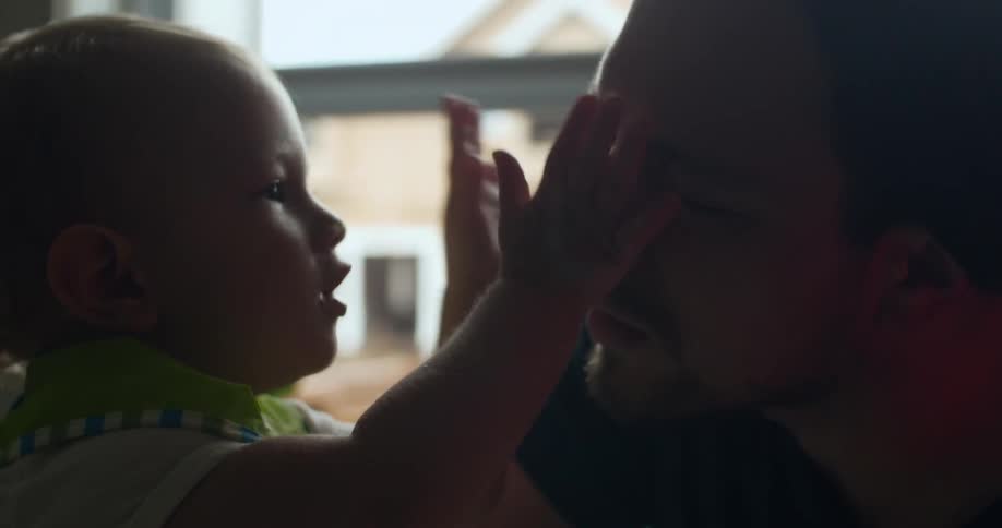 A man plays with a baby
