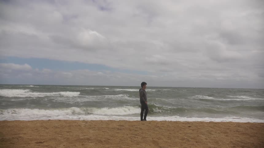 A person walks on a beach in slow motion