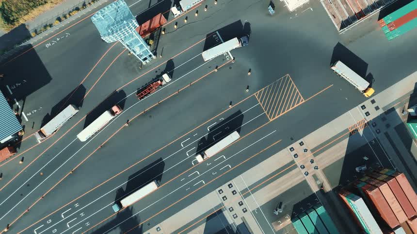 Cargo trucks moving through roads in a large cargo shipping container depot