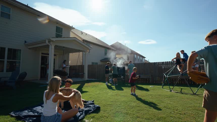 A group of people having fun on several ways in a backyard while a woman is petting a dog