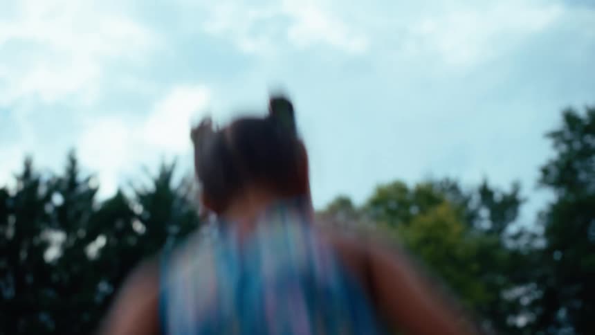 Three children jumping on a trampoline on a backyard