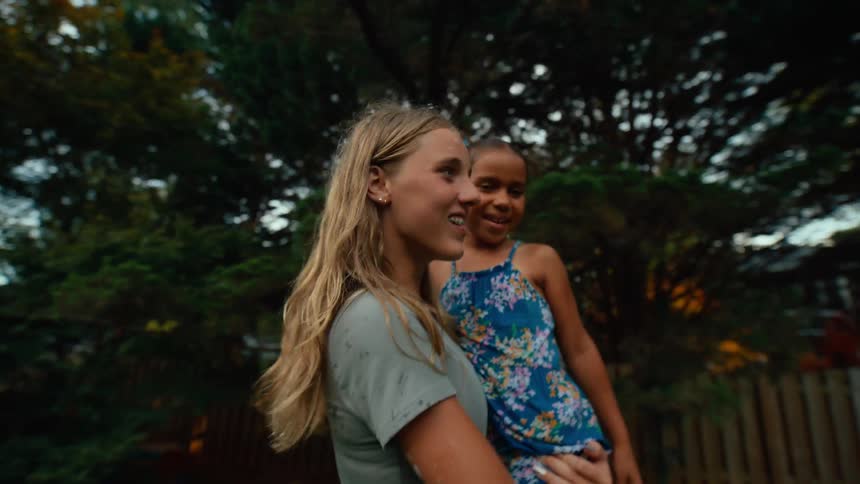 A mother carries her daughter in the yard