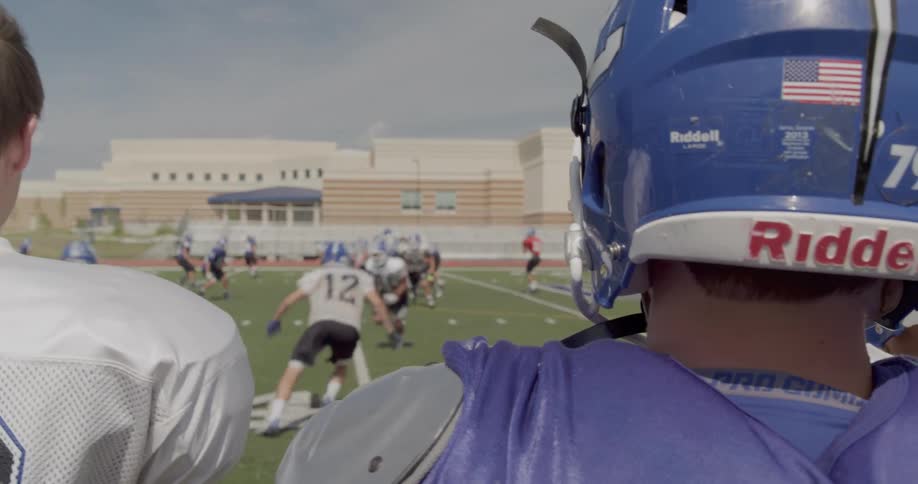 Two football players watch a play during an american football game