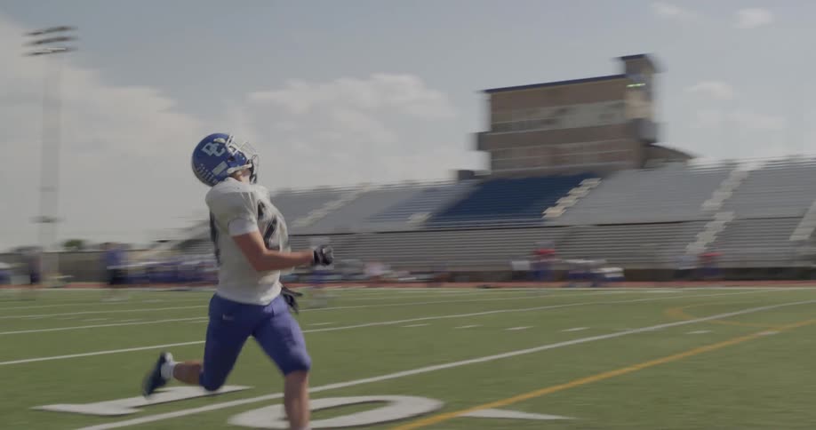 The football player runs and catches the ball for a touchdown