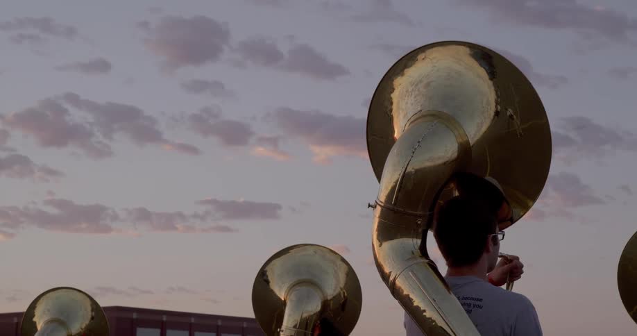 The band are playing tubas outside