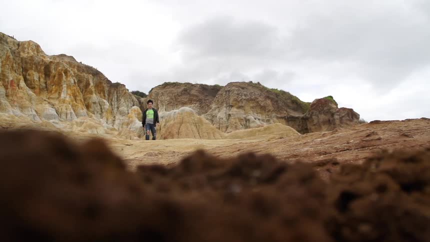 Man walks with mountains behind him