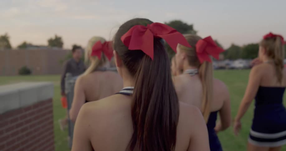 The cheerleaders head towards the football field