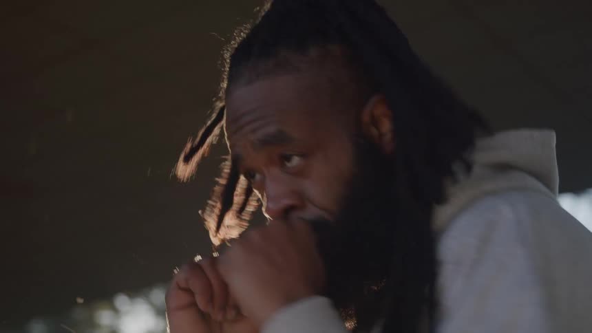 A black man practices shadowboxing while standing outdoors