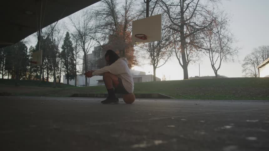 A man sitting on a basketball