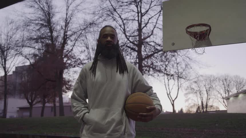 Man holding a basketball on an outdoor court