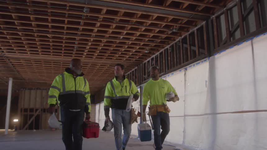 Three men walking on a construction site