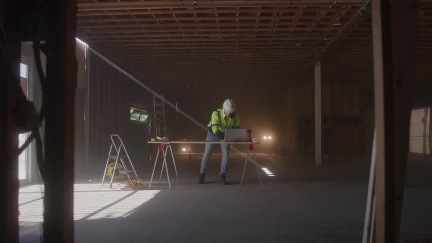 Engineer in helmet working at a table on a construction site