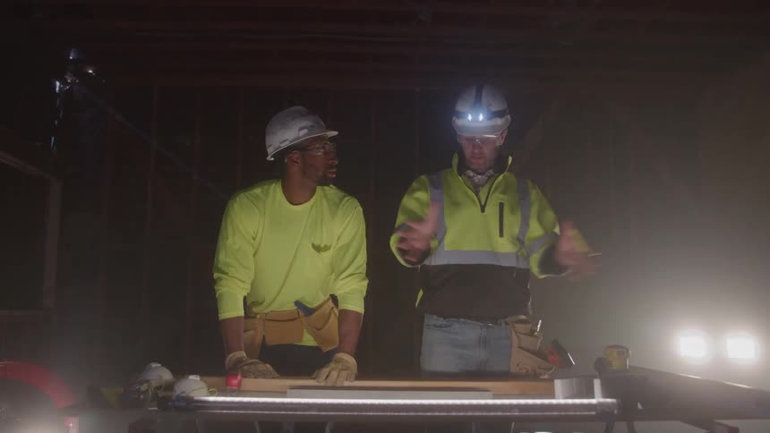The construction workers are planning and talking