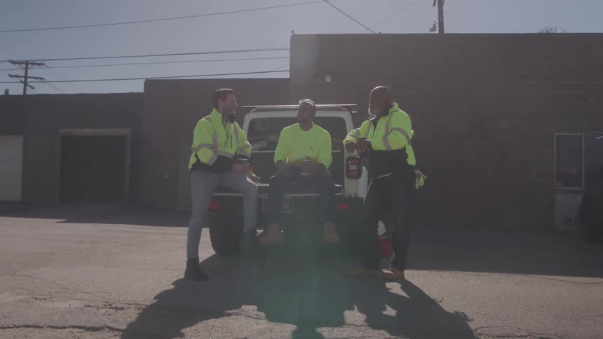 Three men near a car talking