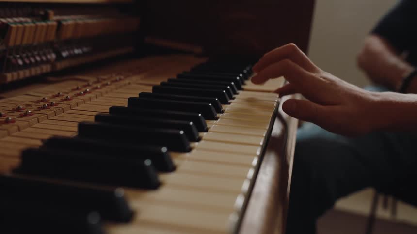 A person is playing the piano with one hand