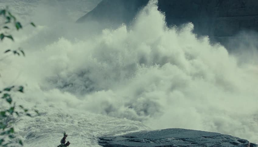 The water rushes off a large cliff