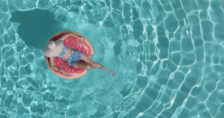 Woman relaxing on a float floating in the pool water