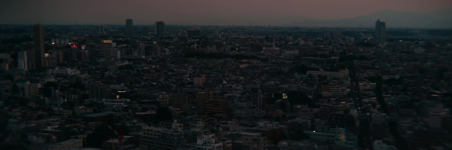 City near the mountains sprawls under a red tinted sky