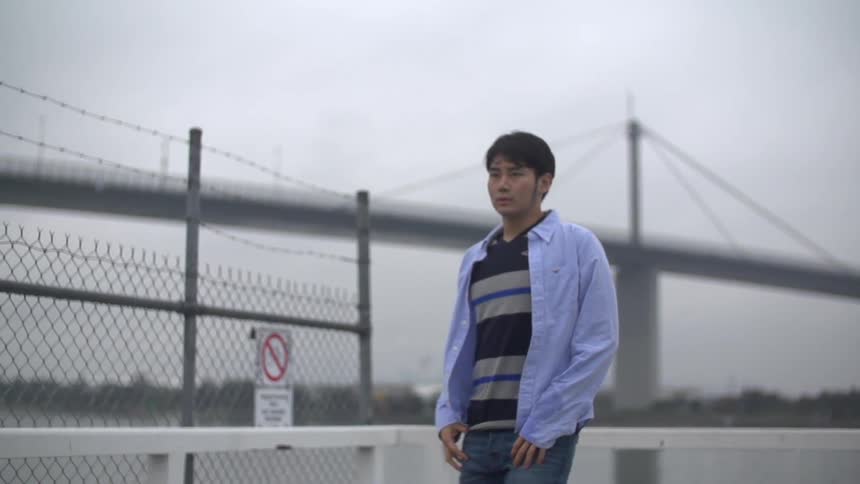A man walks between tall metal fences