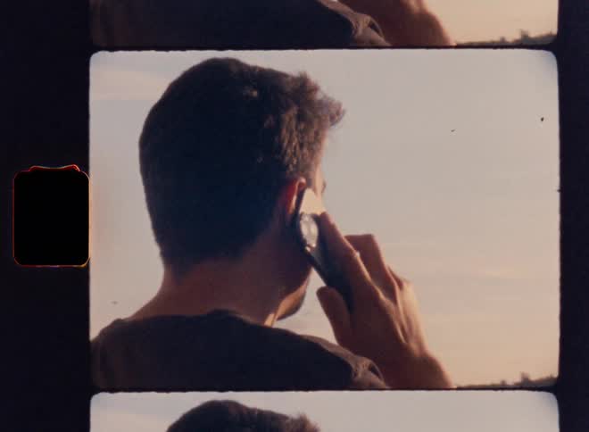 Man standing outdoorson a cloudy day answers a smartphone call