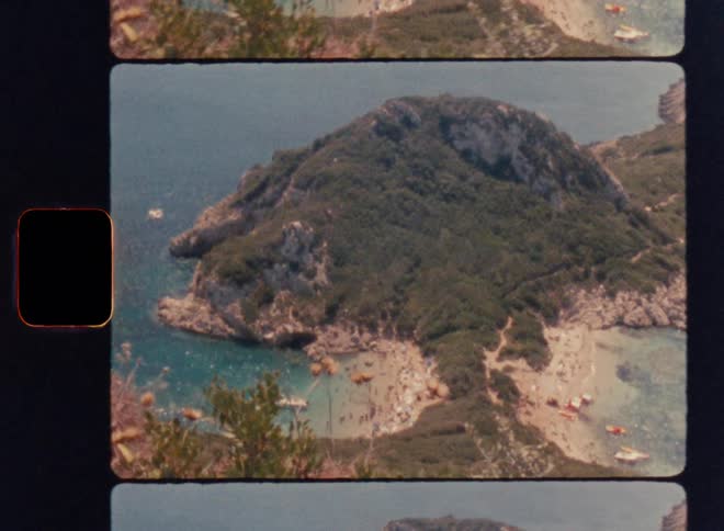 Upward panning cinematic shot revealing a lush green coastal island surrounded by turquoise sea, filmed with nostalgic vintage film grain and authentic analog imperfections, captured on Super 8mm film stock