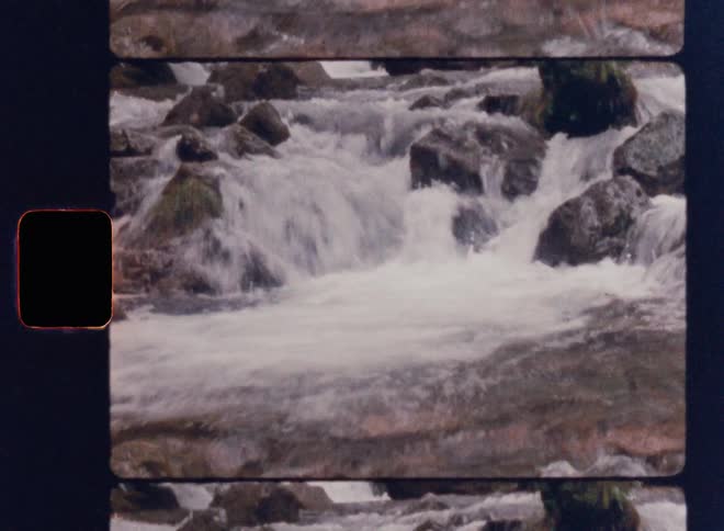The video shows a threepart scene of a waterfall the top and bottom sections display the cascading water while the middle portion focuses on the rocks and the stream a filmsupply watermark is visible in the middle the video ends with a visual glitc