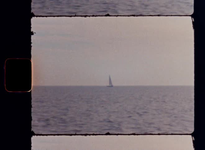 The small sailboat sails in the distance