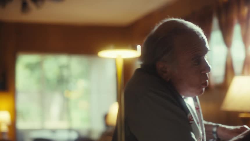 Elderly man watching excitedly in front of the window light
