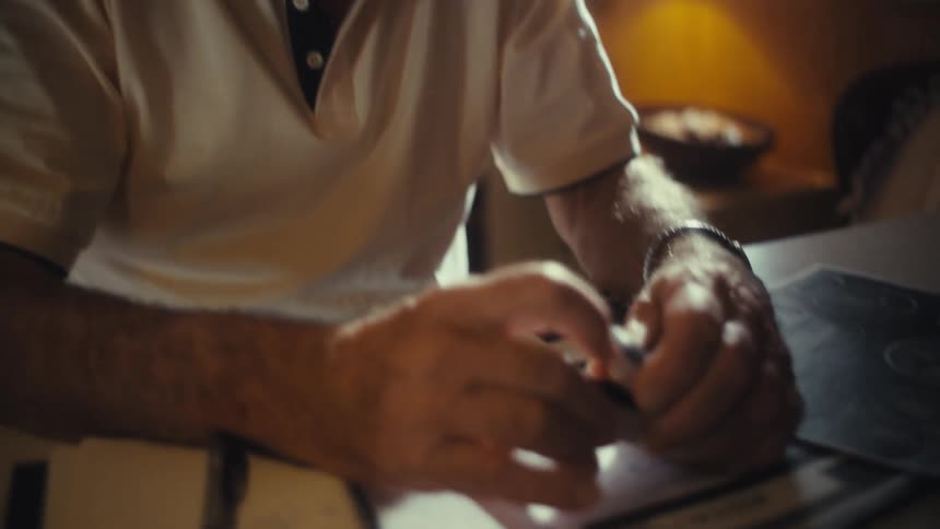 The man puts the vital monitor on his finger while sitting