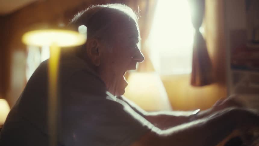 A person excitedly plays a retro video game on an old computer monitor