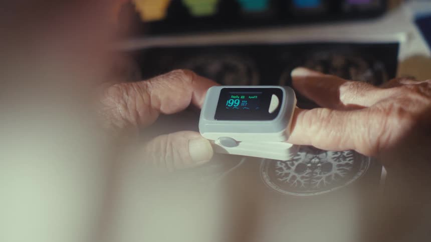 The man attaches the monitor to his finger