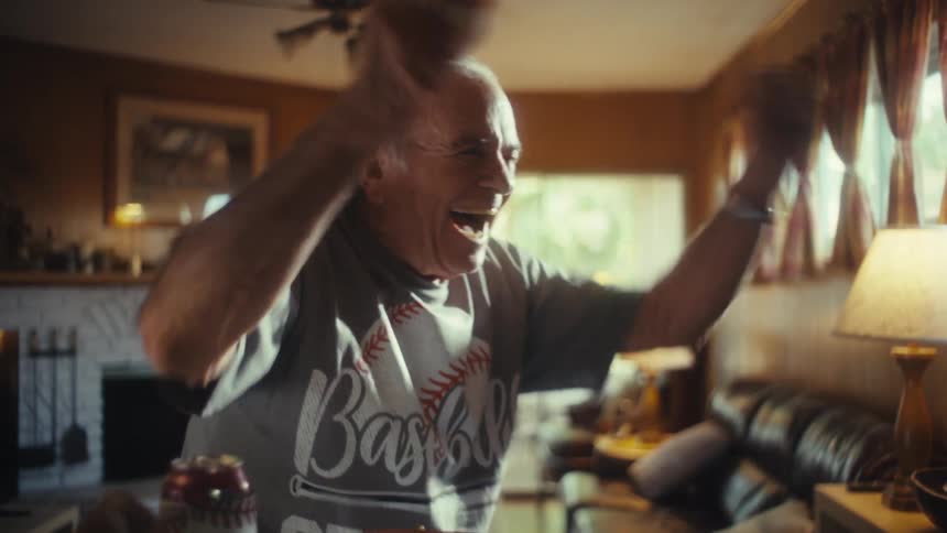 Elderly man celebrating with raised arms and a joyful expression
