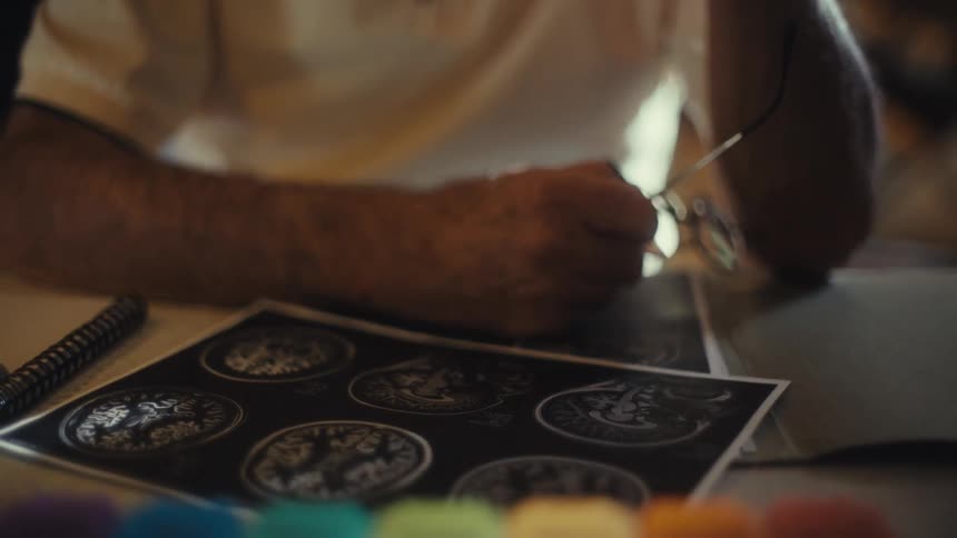 A shot of a sick elderly man with a nasal cannula he is sitting at a desk and looks down at a paper with what appears to be brain scan imagery he picks up his glasses and puts them on as he examines the paper