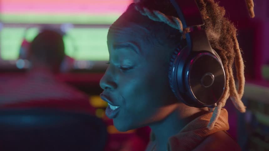 Woman with headphones singing in a studio