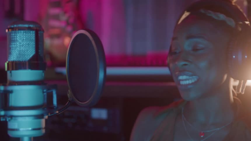 Woman singing into microphone in a studio