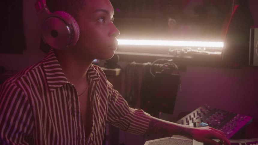 Woman with headphones mixing music in a studio