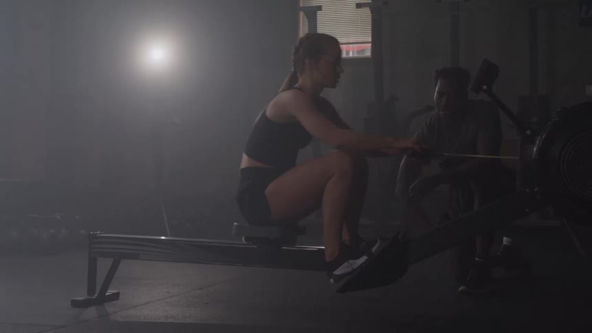 Woman training on a rowing machine at the gym