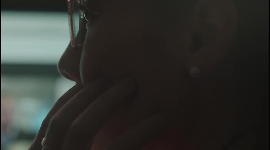 An asian woman looking to a computer screen logged on a virtual meeting with other three people
