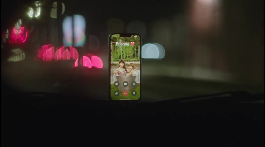 A smartphone attached by holder to the car dashboard at night