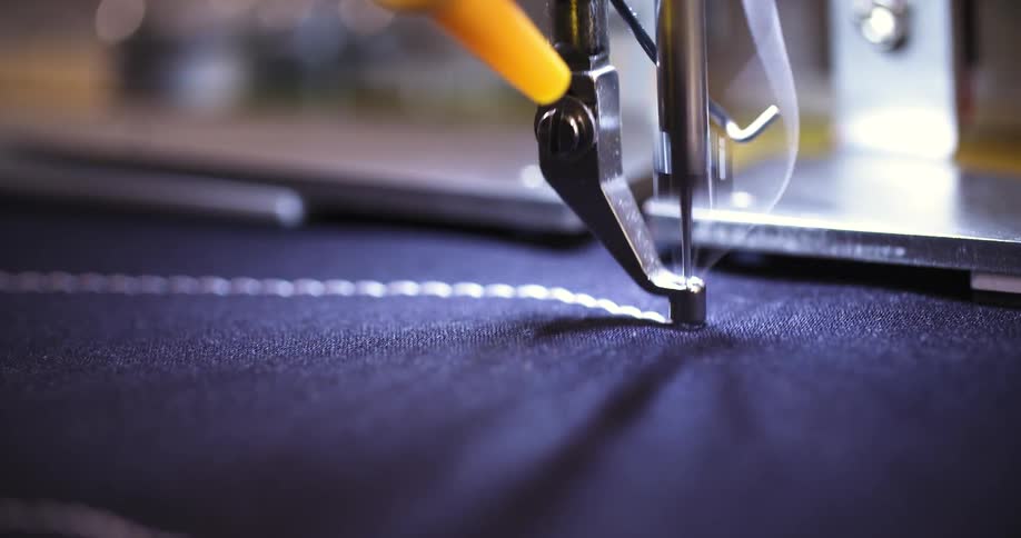 The sewing machine is stitching the fabric